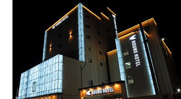 A modern building with multiple floors, prominently featuring the 'HOUND HOTEL' signage.