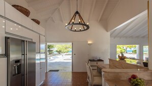 Una cocina moderna con un refrigerador de acero inoxidable, un horno empotrado y una isla grande con un cuenco de fruta.