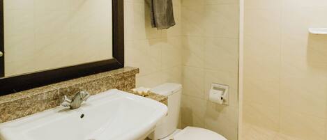 Un baño con lavamanos, inodoro y ducha.