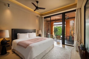 A spacious bedroom with a large bed, a ceiling fan, and a view of a balcony with outdoor furniture. - Sumeru Botanical Estate (Ubud)