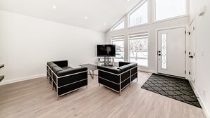 A modern living room with a sofa, a coffee table, and a flat-screen TV.