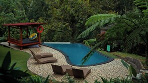 A pool area with lounge chairs, a wooden gazebo, and a lifebuoy. - Kebun Kita Ecolodge (Pupuan)