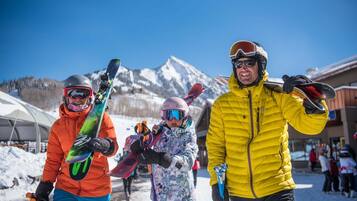 A snowy outdoor scene with people holding snowboards.