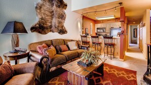 A living room with a leather sofa, a coffee table, and a mounted fur rug. - Crested Butte Mountain Resort (Crested Butte)