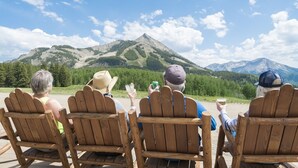 Four wooden Adirondack chairs facing a mountainous landscape. - Crested Butte Mountain Resort (Crested Butte)