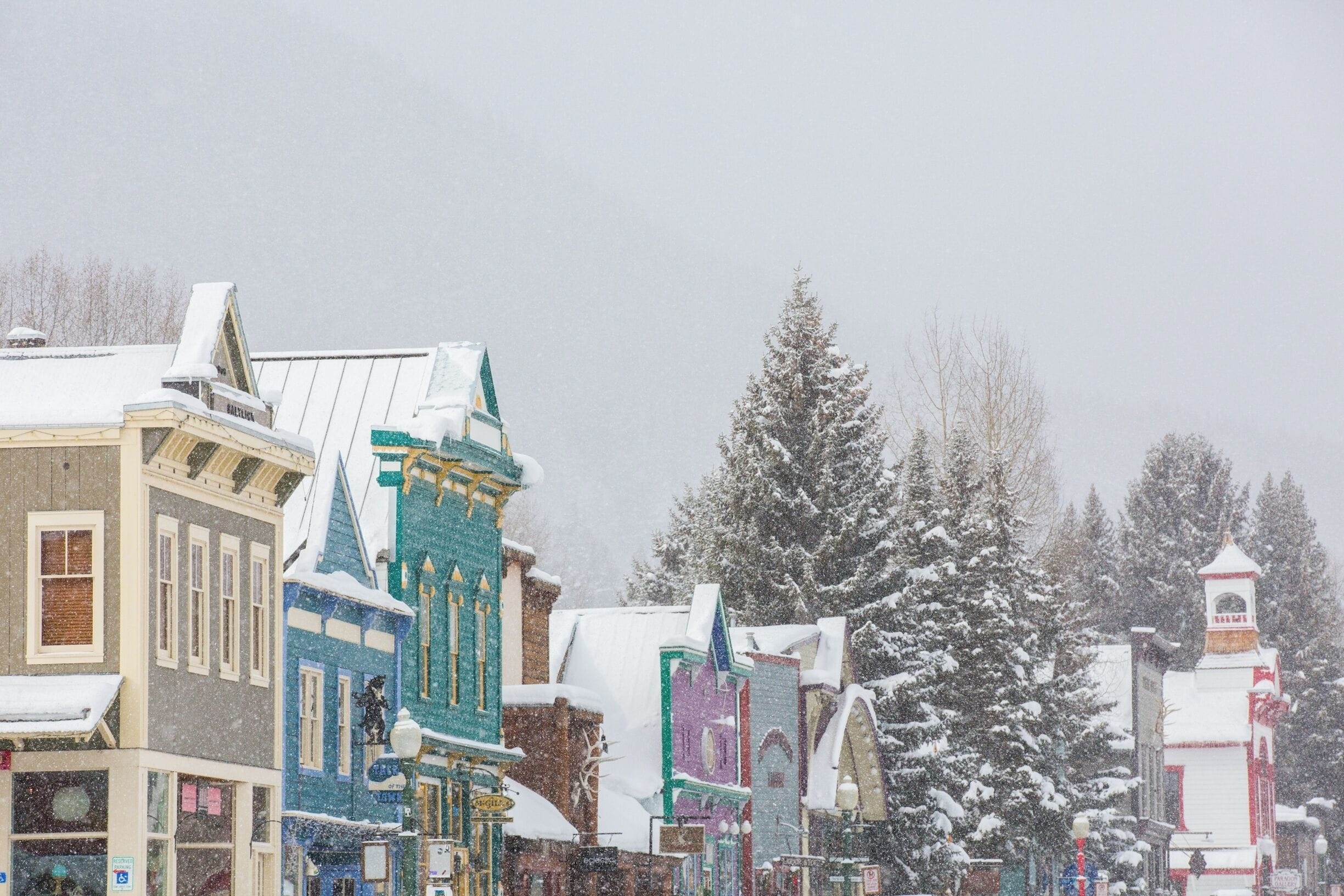 A historic downtown area with snow-covered buildings and a prominent clock tower.