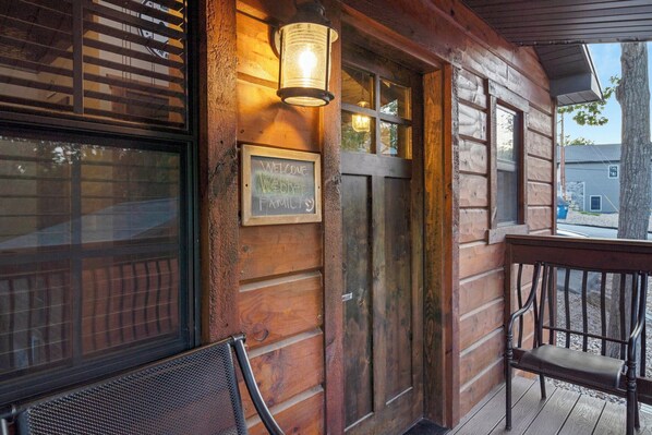 A wooden exterior with a welcome sign, a bench, and a lantern. - Lakeside 2bd/2ba cabin, sleeps 6. Free Use of Kayaks-Ticket DEALS and Resort Perks!! (Branson)