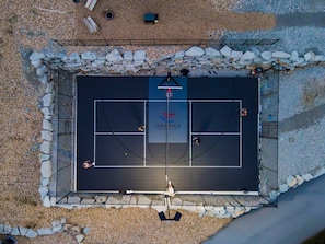 Un campo da tennis all'aperto con bordo in pietra, una rete e il logo di 'TABLEROCK RESORTS'.