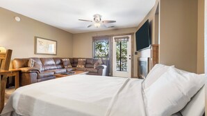 Un dormitorio con una cama grande, un sofá, un escritorio y una televisión.