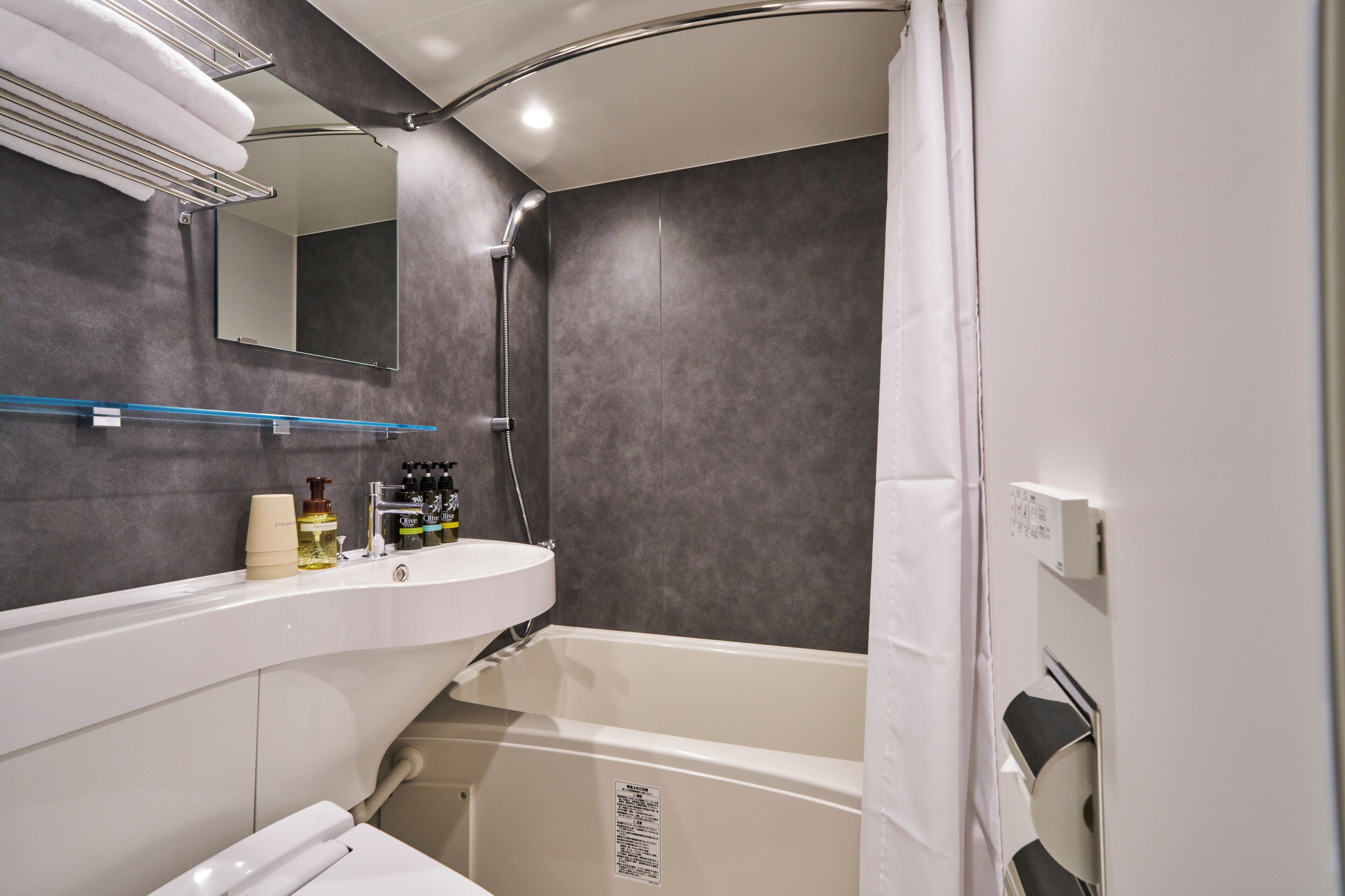 A modern bathroom with a bathtub, a sink, and a mirror.