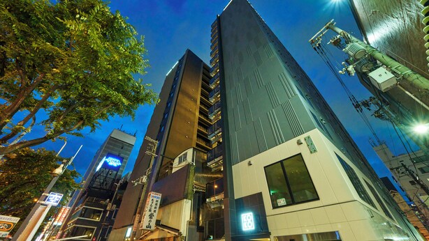 A modern high-rise building with multiple floors, large windows, and a prominent entrance. - KOKO HOTEL Osaka Namba Sennichimae (Osaka)