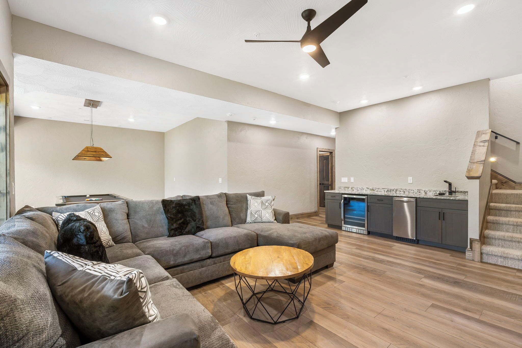 A modern living room with a sofa, coffee table, and pendant light.