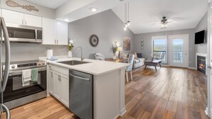 Una cocina moderna con una isla central, electrodomésticos de acero inoxidable y un comedor con vistas.