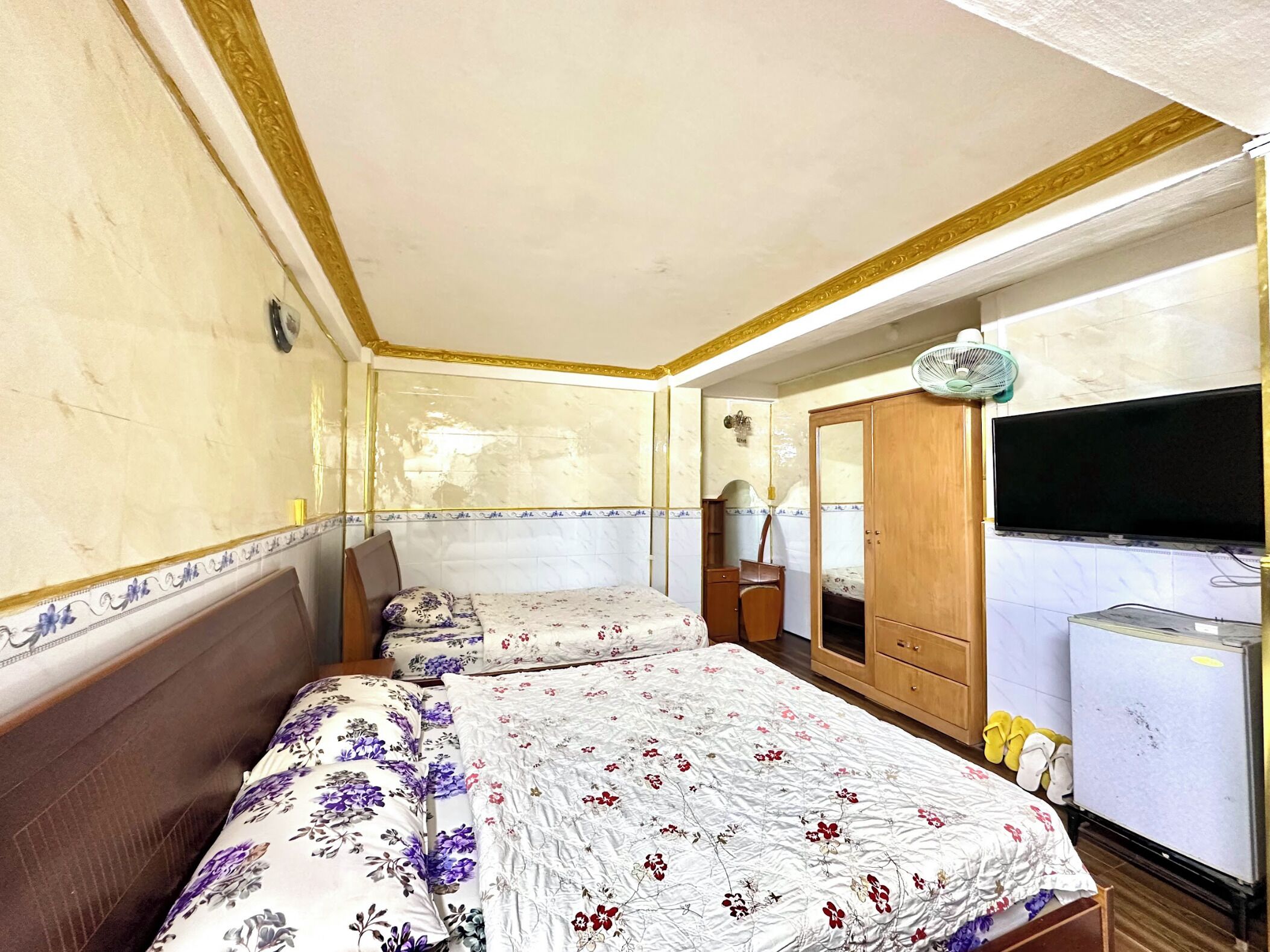 A room with two beds, a TV, and a wardrobe.