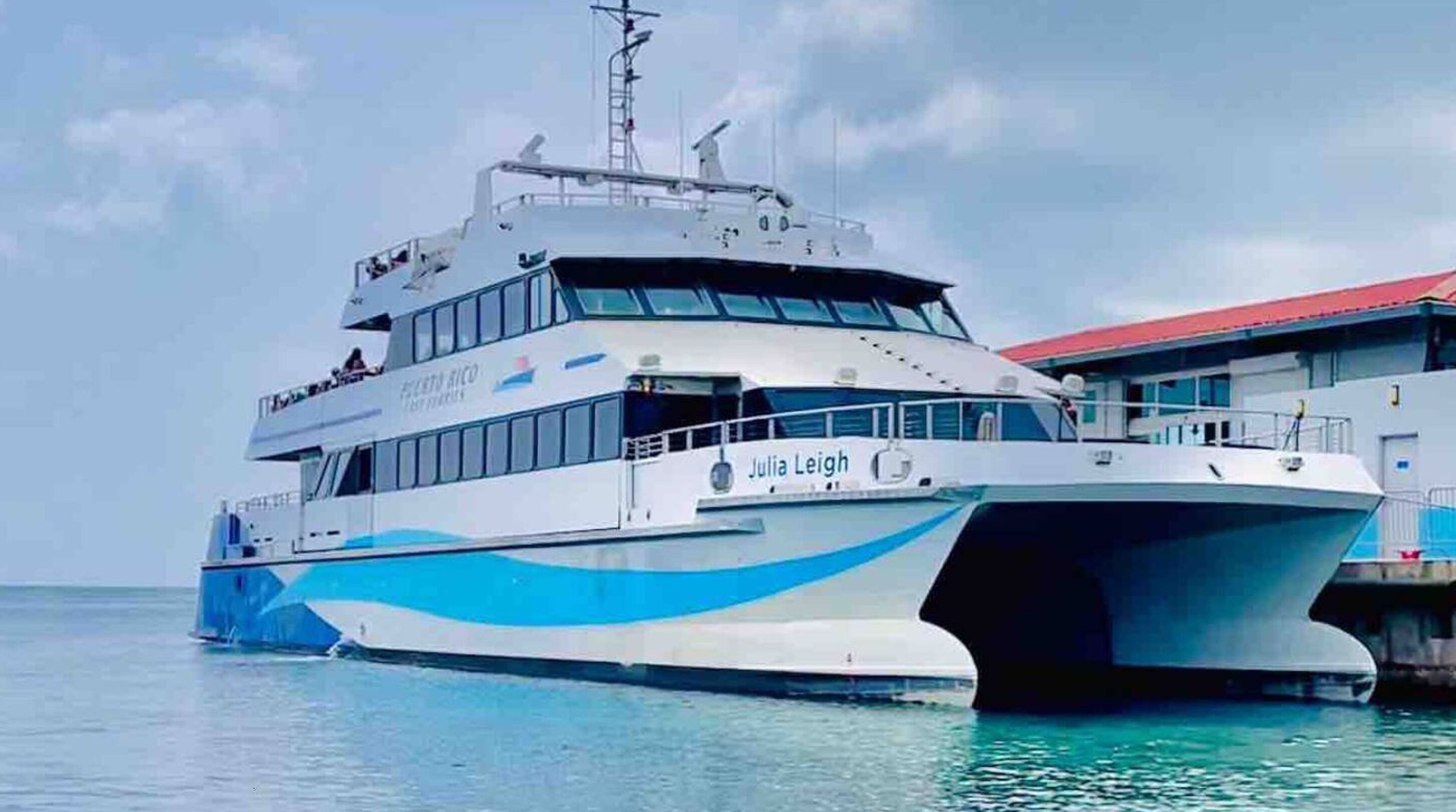 Un grand ferry à plusieurs ponts, portant l’inscription « Julia Leigh » sur le côté, était amarré à un quai.