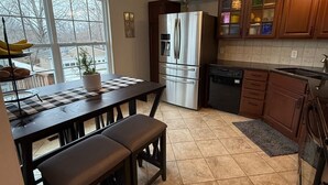 A kitchen with a large island, a refrigerator, and a dishwasher. - NEW LISTING! Home with a POOL, PARK, and close to Arrowhead & Kauffman! (Blue Springs)