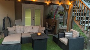 A covered patio with wicker furniture, a small table, and string lights. - NEW LISTING! Home with a POOL, PARK, and close to Arrowhead & Kauffman! (Blue Springs)