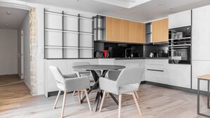 Une cuisine moderne avec un coin repas, comprenant une table ronde et quatre chaises grises.