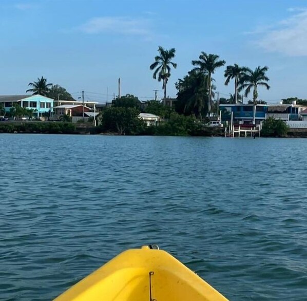 A yellow boat on calm water with a coastal town in the background. - Hotel Martin  (Corozal)