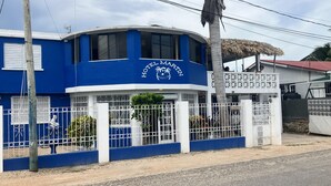 A blue building with a sign reading "Hotel Martin" and a white fence surrounding it.