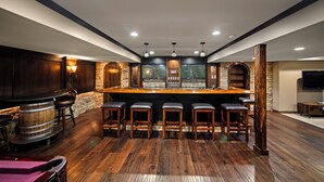 Eine Bar mit Holzhockern, einer Bar und einer Steinwand.