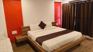 Ein modernes Schlafzimmer mit einem hölzernen Bett, weißer Bettwäsche und einer roten Akzentwand.
