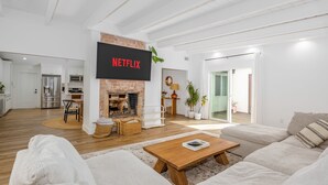Una sala de estar moderna con chimenea, un televisor de pantalla plana montado en una pared de ladrillo y un sofá.