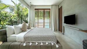 A modern bedroom with a large bed, a TV, and a balcony with plants. - Villa Kayu Pererenan (Canggu)