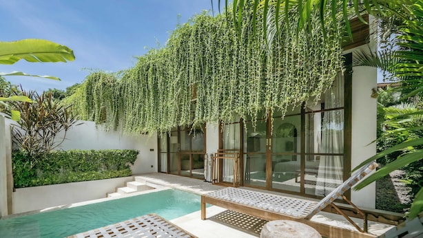 A modern outdoor pool area with lounge chairs and a wooden bench. - Villa Kayu Pererenan (Canggu)