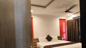 Una camera da letto moderna con un letto di legno, una ventola a soffitto e una parete decorata di rosso.