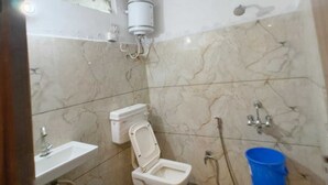 Un bagno con il water, lavandino e doccia.
