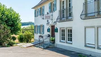 Un edificio a due piani con un cartello che riporta 'Gasthof Schwert' e un balcone con ringhiere in ferro battuto.
