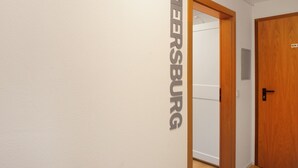 A hallway with a door labeled 'MEERSBURG' and a wooden door with a sign 'KEIN ZUR' on it. - Room 'Meersburg' with shared terrace and Wi-Fi (Salem)