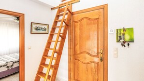 Una puerta de madera con un ojo de cerradura y un llavero pequeño con herramientas colgadas en la pared.