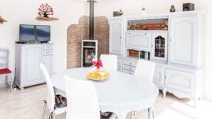 Una sala de estar moderna con chimenea, muebles blancos y televisor.