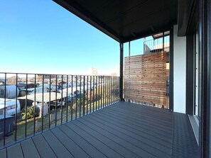 A balcony with a view of parked RVs and buildings.