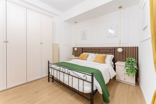 A bedroom with a bed, bedside table, nightstand, and wardrobe. - Emerald Garden Suite, Flat in San Giovanni Area (Roma)