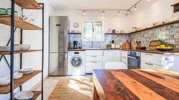 Een koelkast, een magnetron, een oven, kookgerei, borden en bestek