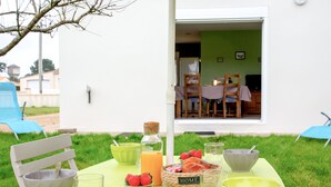 Un espace de restauration en plein air avec une table dressée pour deux personnes, proposant une variété de plats et de boissons.