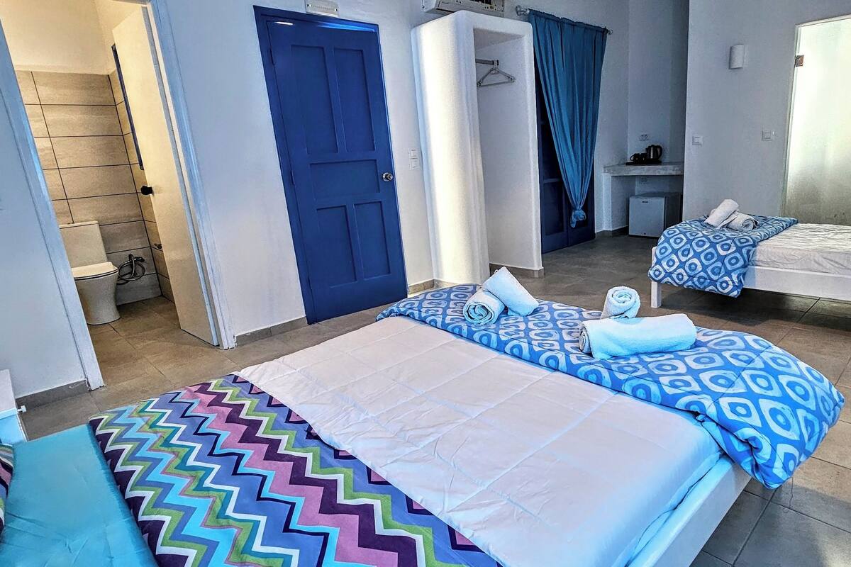 Habitación de hotel con dos camas, baño y escritorio.