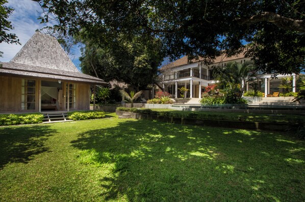 A building with a sloped roof, surrounded by well-maintained grass and trees.