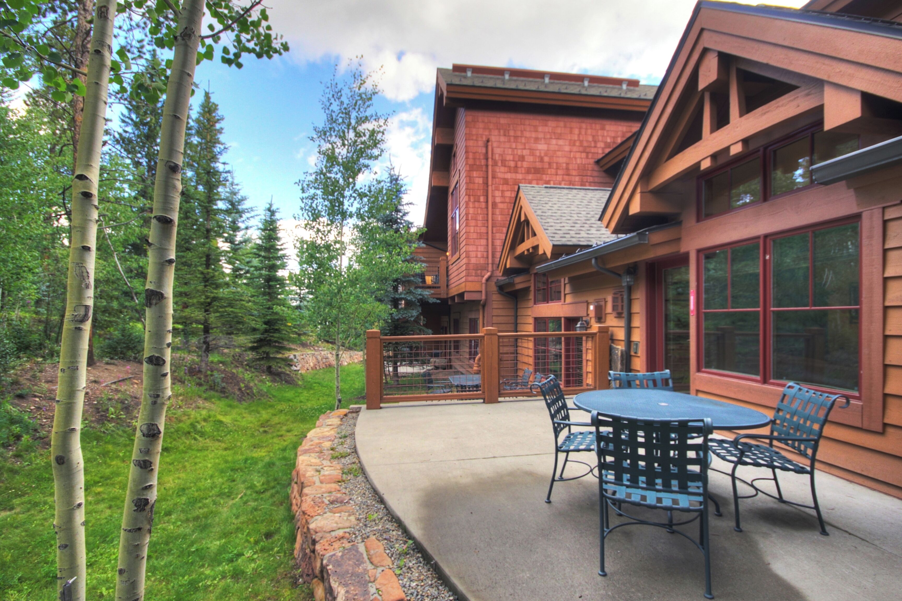 A building with a brick exterior, large windows, and a patio with outdoor furniture.