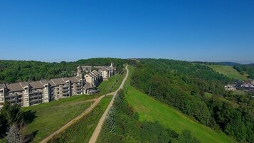 Un hotel moderno con varios pisos, un patio central y una vista panorámica de un área boscosa.