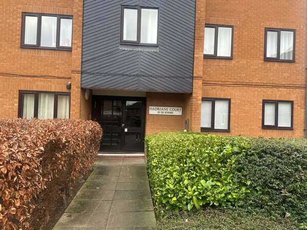 A building with a sign reading "HADRIANS COURT 10-32 (EVENS)".