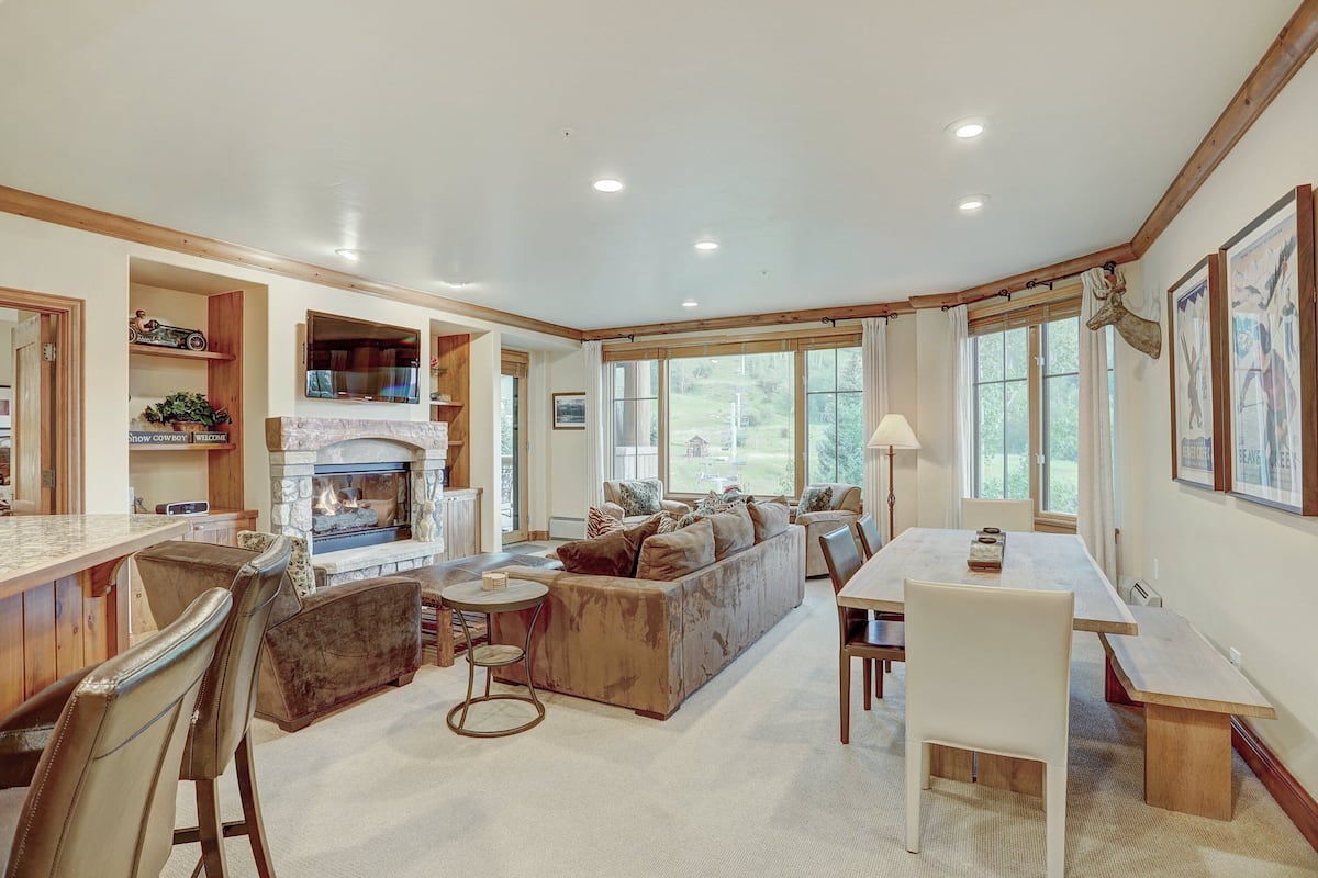 A spacious living area with a fireplace, a dining table, and a sofa.