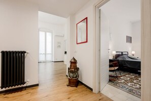 A hallway with a radiator, a lantern, and a bed with a patterned rug.