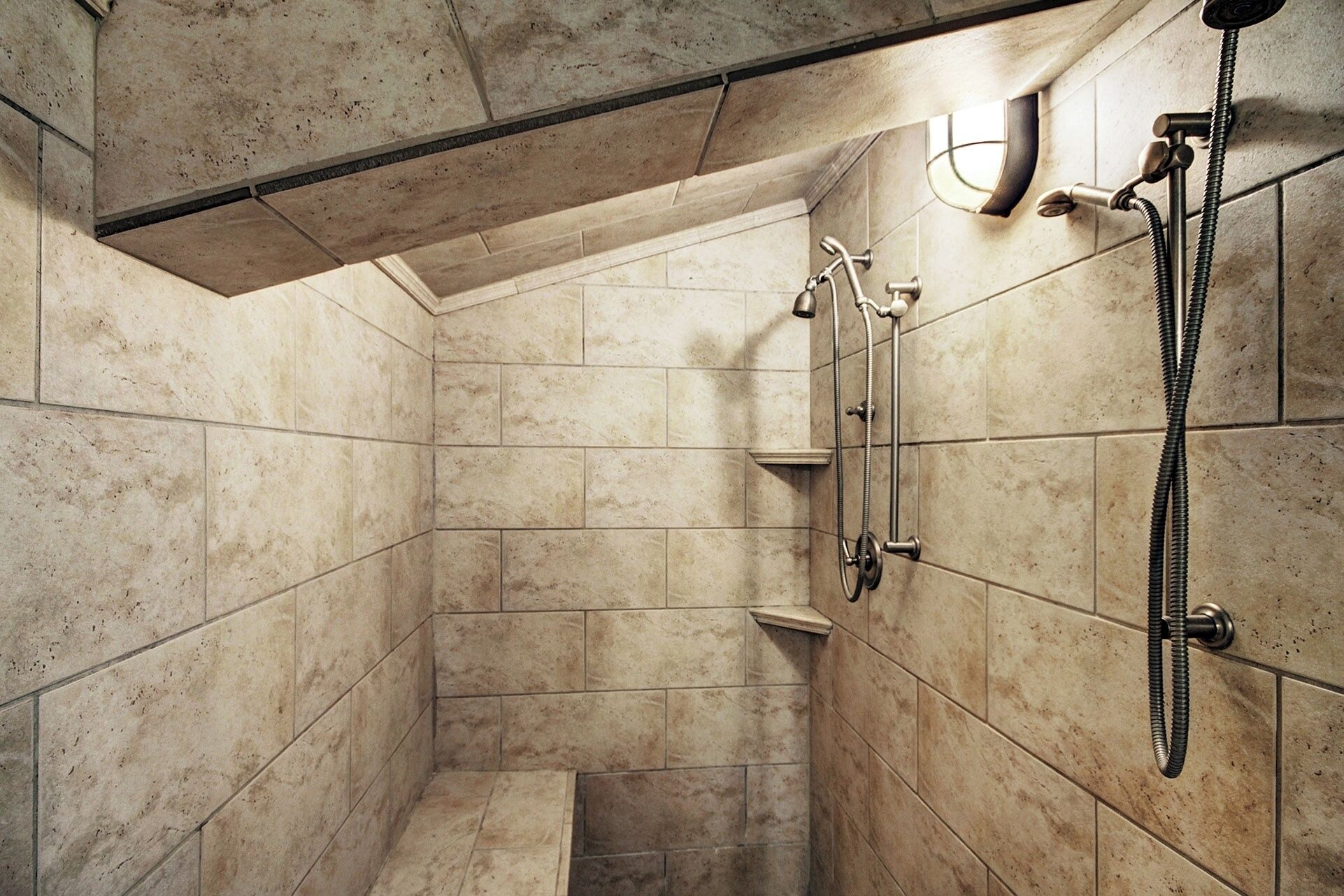 A small, tiled shower room with a showerhead and handheld shower attachment.