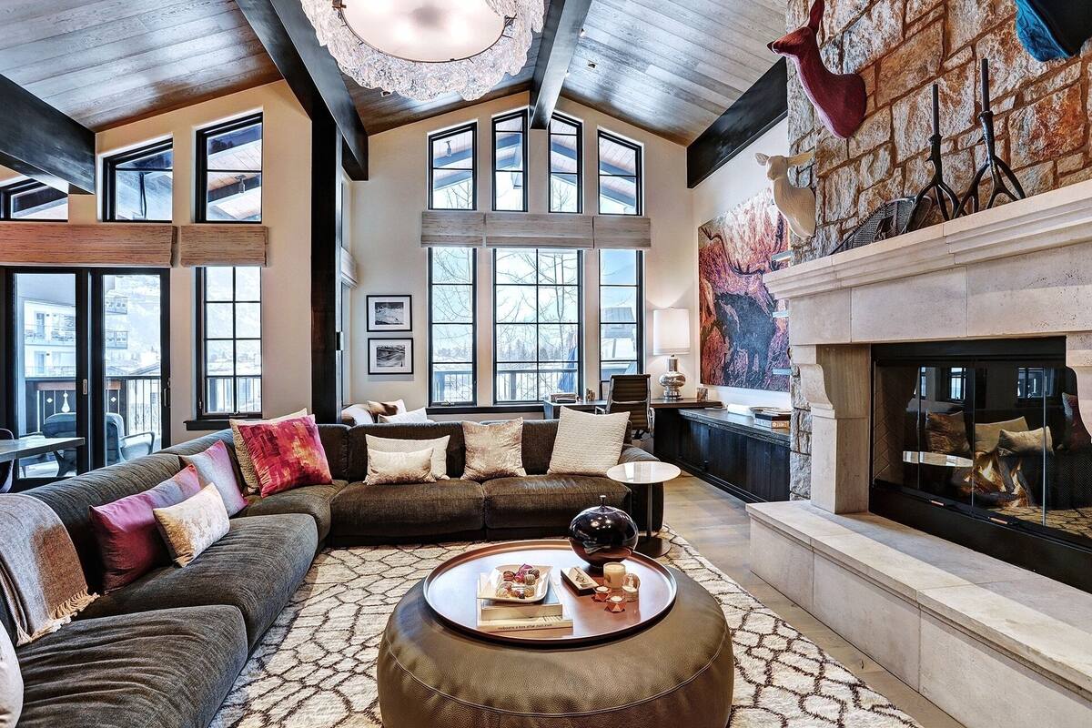 A spacious living room with a fireplace, large windows, and a cozy seating area.