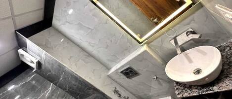 Une salle de bain moderne avec un meuble-lavabo en marbre, un évier et une douche.