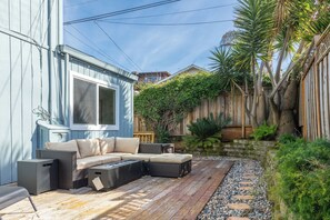 A patio with a sofa, a table, and a fire pit.